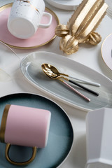 New luxury cutlery view from above on a isolated white background. Top view. Porcelain tea cup on pink saucer with gold. Trendy Coral plate tones. Flat lay view. Cactus decoration.