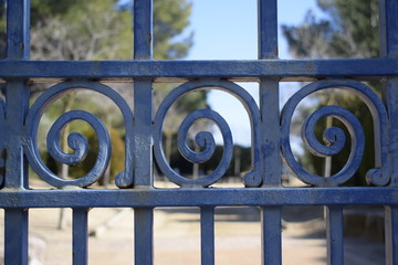 Verja en forma de espiral azul, de hierro, de fondo parque