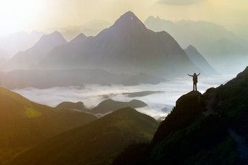 Wide mountain panorama. Small silhouette of tourist with backpack on rocky mountain slope with...