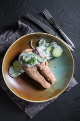 A piece of grilled salmon with cucumbers and Greek yogurt
