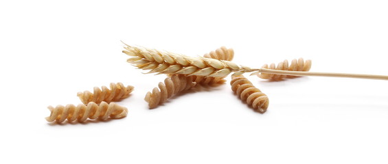 Wholemeal pasta with wheat ears isolated on white background