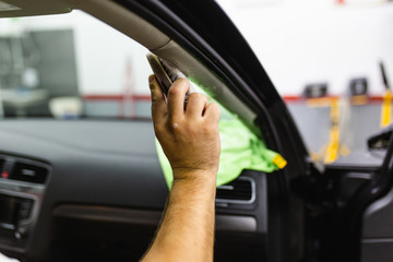 A man cleaning car interior, car detailing (or valeting) concept. Selective focus.