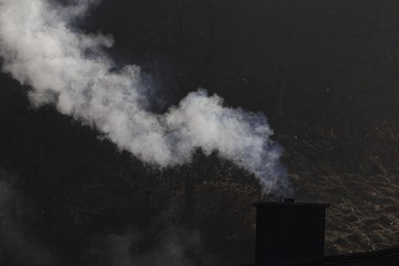 White smoking chimney with a dark background