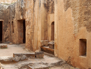 tomb doors and niches in a carved sandstone wall forming a street like view in the temple of the kings area in paphos cyprus