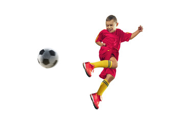 Fototapeta premium Young boy kicks the soccer ball. Isolated photo on white background. Football player in motion at studio. Fit jumping boy in action, jump, movement at game.