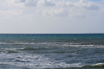 Multicolored sea and clouds in the blue sky