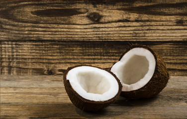 broken coconut into two parts on a wood background