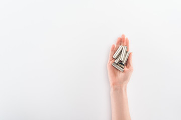 Partial view of woman holding batteries on grey background