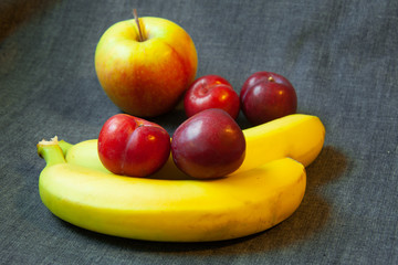 Assorted fruits - bananas, apples, plums.