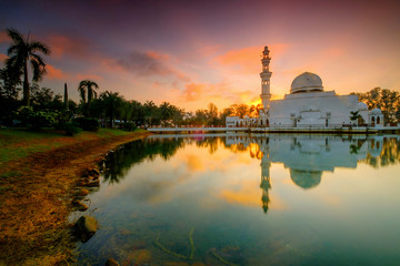 Beautiful sunrise over the majestic mosque, Masjid Tengku Tengah Zaharah - Masjid Terapung (Floating Mosque) located in Terengganu, Malaysia . Soft focus due to slow shutter shot.