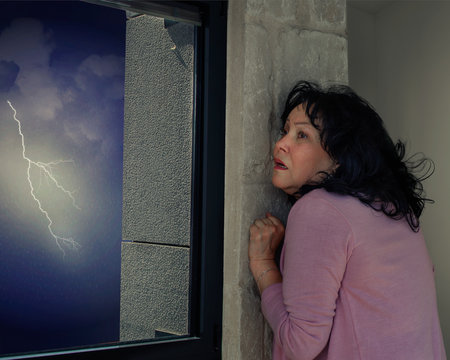 Middle-aged woman is afraid of thunderstorms