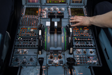 Pilot's hand dialing in flight values in  a commercial airliner airplane flight cockpit during...