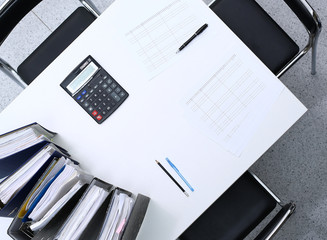 Binders with papers are waiting to be processed with bookkeeper. Internal Revenue Service inspector...