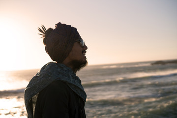 Young Asian Bearded Tourist man with Dreadlocks and scarf on head Walking on the Ocean Coast in...