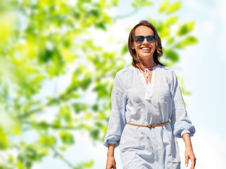 people and leisure concept - happy smiling woman over green natural background