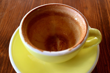 Empty cup of finished drinking cappuccino coffee isolated on wooden table
