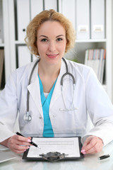 Doctor woman at work. Physician filling up medical history records form at the desk. Medicine, healthcare  concept