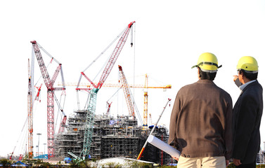 Chemical plant under construction with big crane with engineer working on site