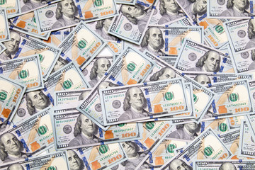 One hundred dollar bills on the table as background