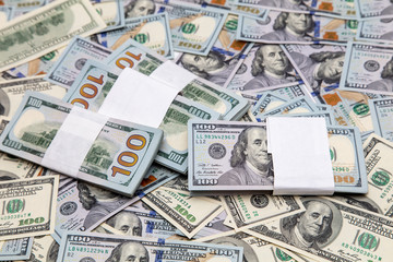 One hundred dollar bills on the table as background