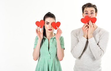Handsome man and pretty girl in love. Man and woman couple in love hold red heart valentines cards...
