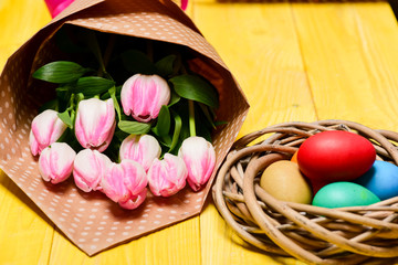 Spring holiday. Tradition celebrate easter. Happy easter season. Easter is coming. Collecting easter eggs. Spring vibes. Colorful eggs and bouquet fresh tulip flowers on yellow table background
