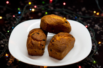 Fototapeta na wymiar Festive cupcakes with raisins on a black background.