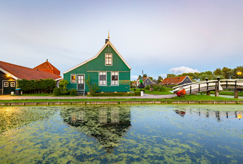 Naklejka na ściany i meble Typically traditional Dutch house, windmill, historical architecture and bridge over water at the Zaanse Schans,