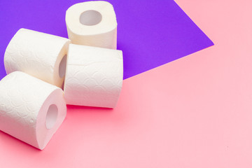 White toilet paper rolls on bright color block background