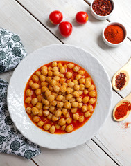Vegetarian tasty spicy chick pea soup on a wooden background / Cheakpea stew/ Turkish nohut pilaki 