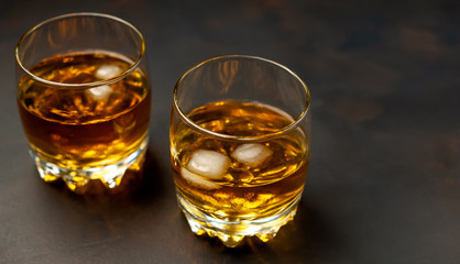 two glasses of whiskey with ice on the concrete