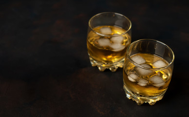 two glasses of whiskey with ice on the concrete