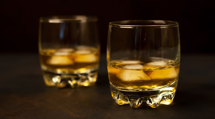 two glasses of whiskey with ice on the concrete