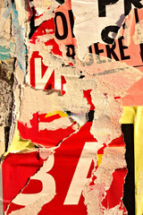 Old grunge ripped torn vintage collage colorful street posters creased crumpled paper surface placard texture background backdrop