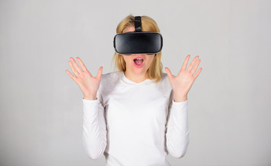 Beautiful woman wearing virtual reality goggles in studio. Woman using VR device. Woman enjoying...