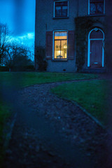 Illuminated window of house in twilight.