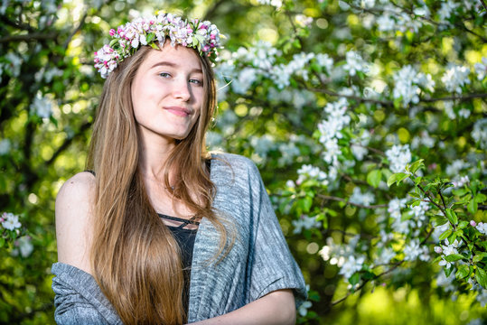 Beautiful young woman in spring blossoming garden