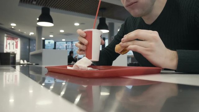 timelapse man eats burger, drinks sweet carbonated water in fast food restaurant