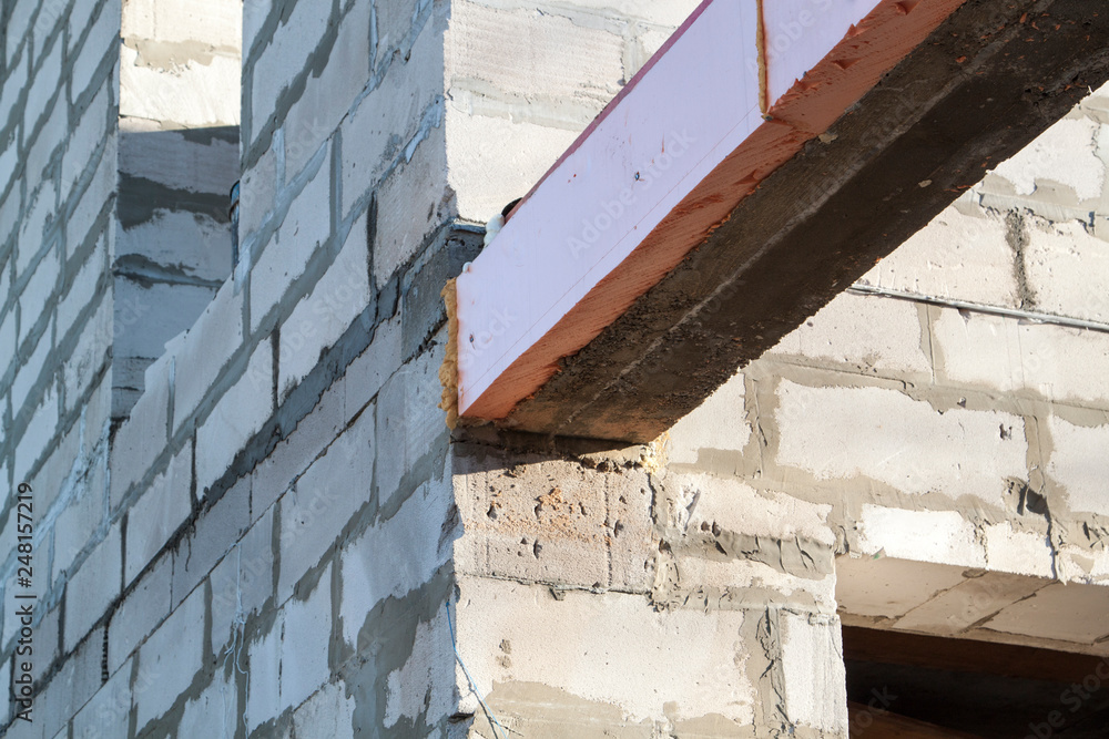 Poster close-up view of the docking concrete beam with a wooden log to the foam block wall of a country cot