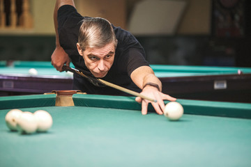 the player takes aim at the ball in Billiards