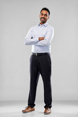 business, office worker and people concept - happy indian businessman in shirt over grey