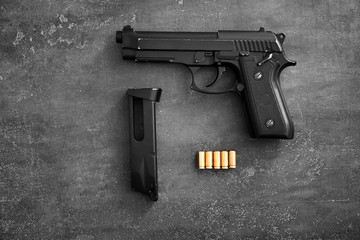 Pistol, bullets and magazine on wooden background