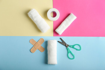 Items from first aid kit on color background