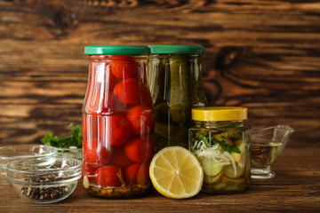 Glass jars with fermented vegetables on wooden table