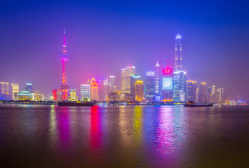 Obraz na płótnie Canvas Shanghai by the Huangpu River on a foggy night, China city skyline