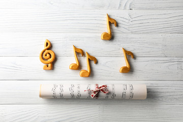 Rolled music sheets on white wooden background