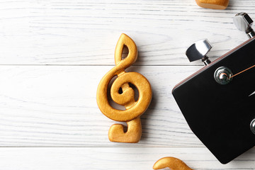 Guitar and violin clef on white wooden background, closeup