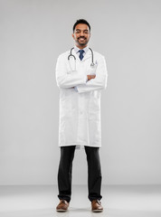 medicine, profession and healthcare concept - smiling indian male doctor in white coat with stethoscope over grey background