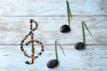 Music notes and violin clef made of natural materials on wooden background