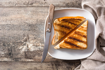 Grilled cheese sandwich on wooden table. Top view. Copyspace